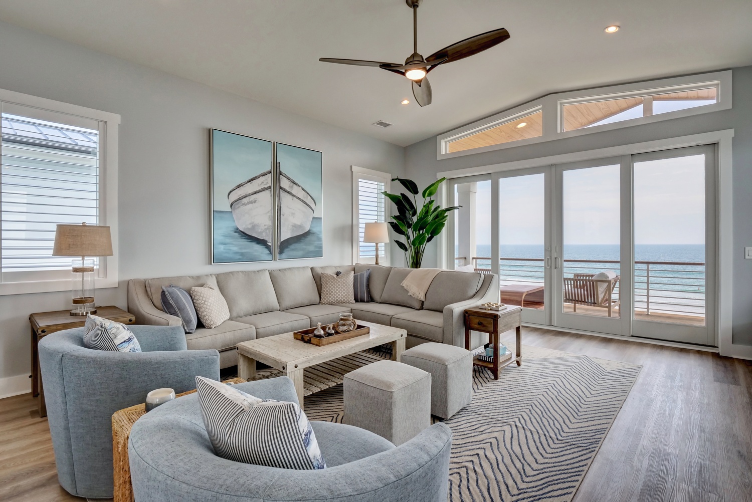 Beach House project living room with soft blue seating, ivory upholstery, and ocean views