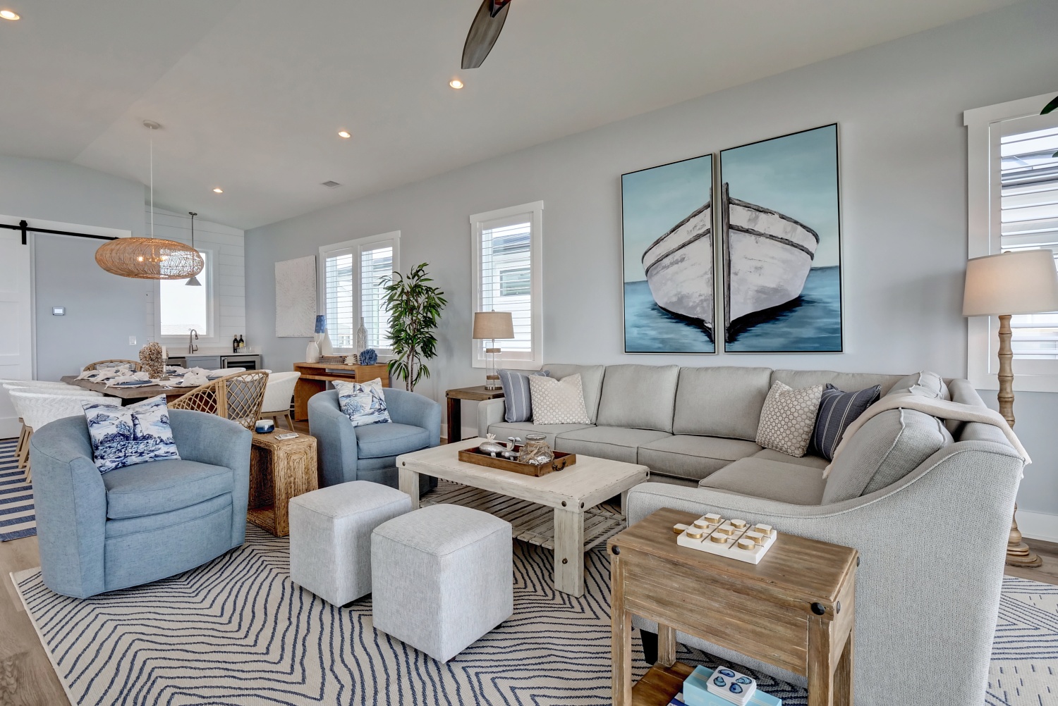 Beach House living and dining spaces with blue armchairs, ivory sectional, and natural wood accents
